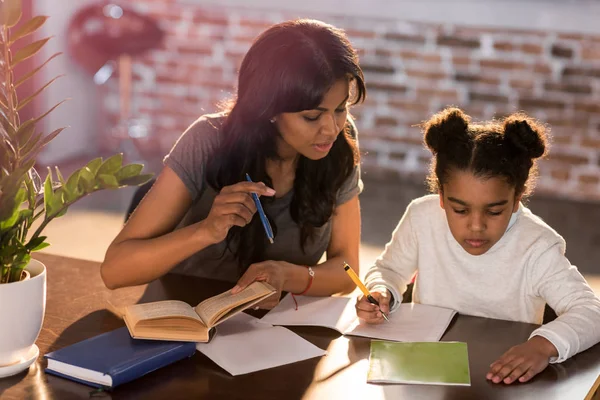 Mère avec sa fille faisant ses devoirs — Photo de stock