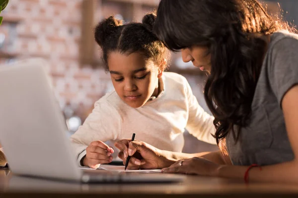 Madre aiutare figlia con i compiti — Foto stock