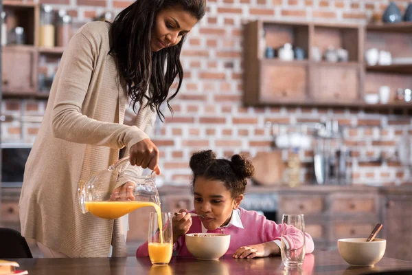 Madre vertiendo jugo en el vaso - foto de stock