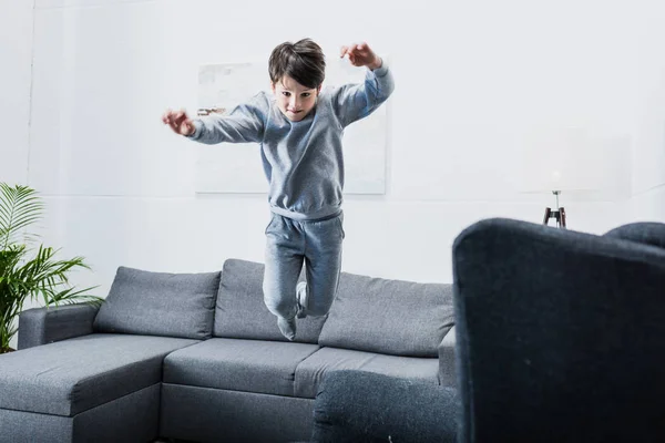 Junge springt auf Couch — Stockfoto