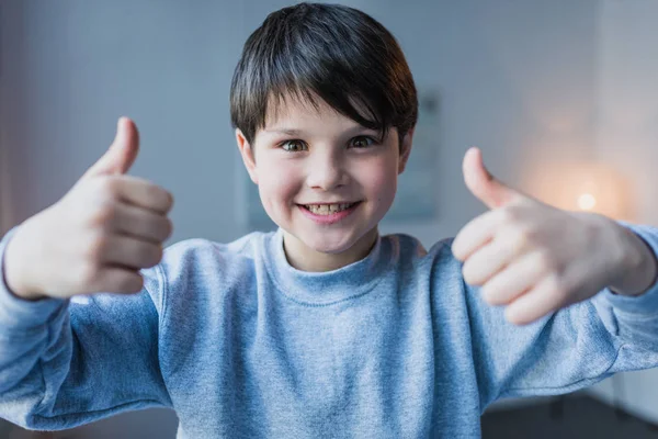 Niño pequeño haciendo gestos pulgares hacia arriba - foto de stock