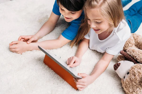 Kleine Jungen und Mädchen mit digitalem Tablet — Stockfoto