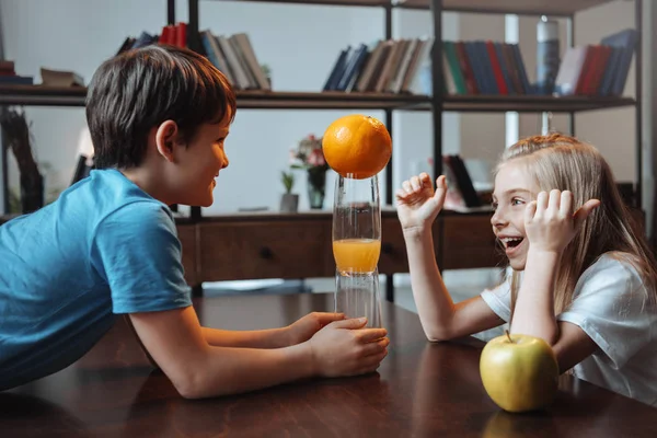 Boy and girl playing with glasses and fruits — Stock Photo