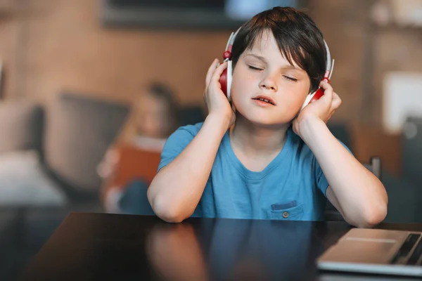 Niño niño escuchando música en auriculares - foto de stock