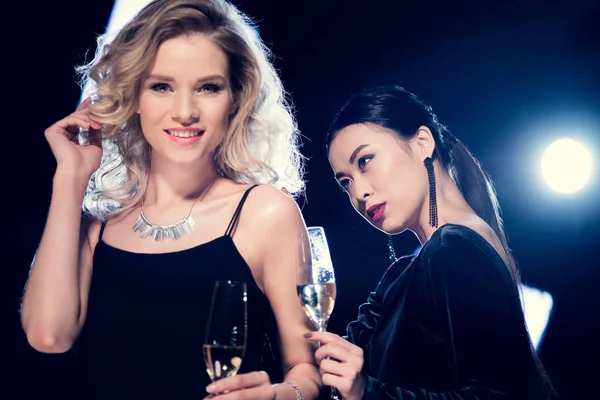 Multicultural glamour girls with champagne — Stock Photo