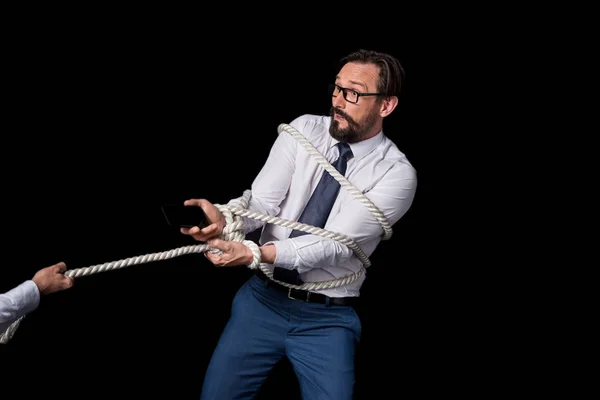 Person pulling tied businessman — Stock Photo
