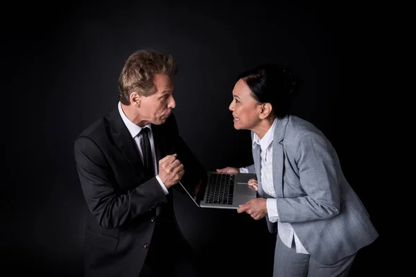 Business colleagues fighting for laptop — Stock Photo