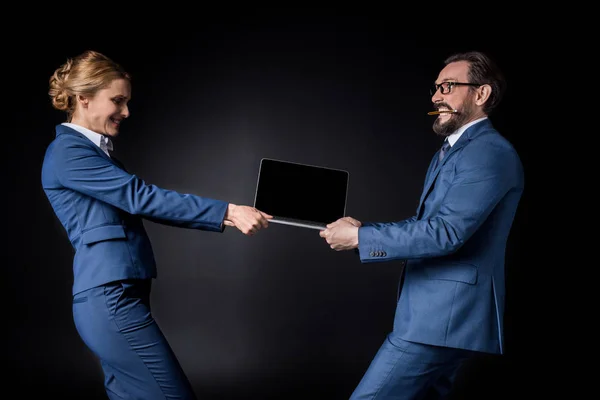 Business colleagues fighting for laptop — Stock Photo