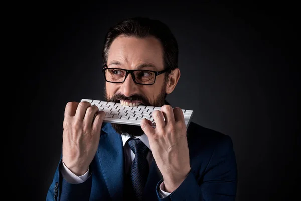 Businessman biting keyboard — Stock Photo