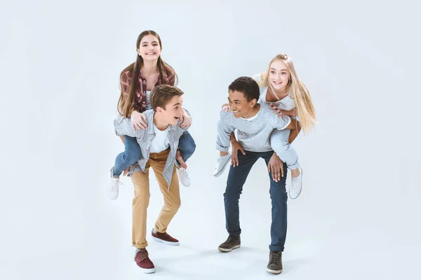 Multikulturelle Teenager huckepack zusammen — Stockfoto