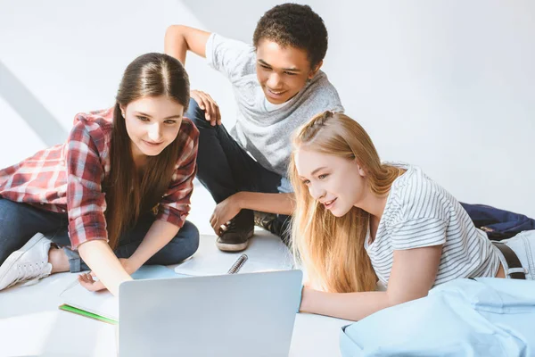 Adolescentes sorridentes multiétnicos com laptop — Fotografia de Stock