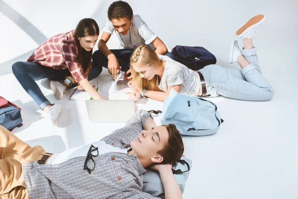 Multiethnic teenagers using laptop together — Stock Photo