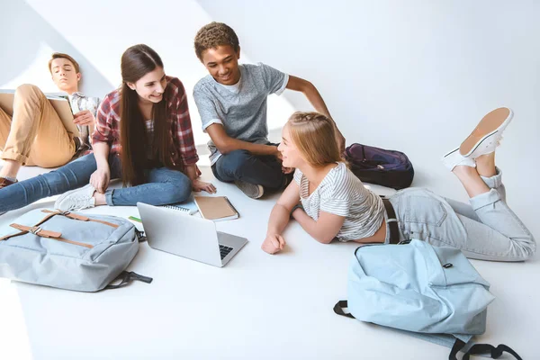 Adolescentes multiculturales con portátil - foto de stock