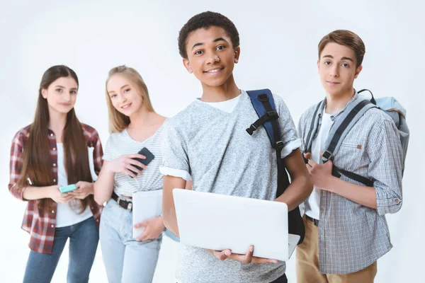 Adolescentes multiculturales con dispositivos digitales - foto de stock