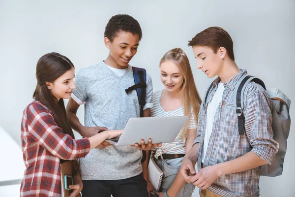 Multiethnic teenagers using laptop — Stock Photo