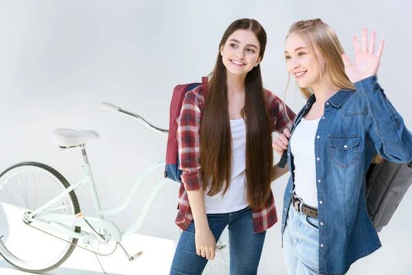 Smiling teenagers waving to friend — Stock Photo