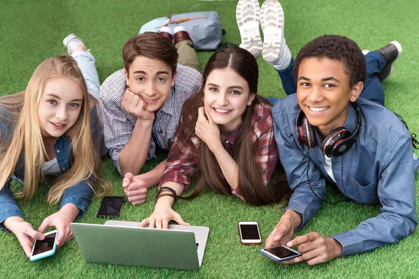 Multicultural teenagers using laptop — Stock Photo