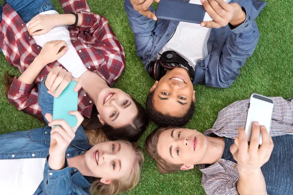 Adolescentes multiétnicos con teléfonos inteligentes - foto de stock