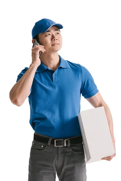 Young asian courier talking smartphone — Stock Photo