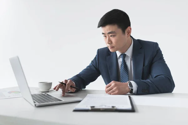 Asiatischer Geschäftsmann mit Laptop am Arbeitsplatz — Stockfoto