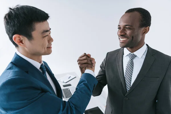 Empresarios multiétnicos dándose la mano - foto de stock