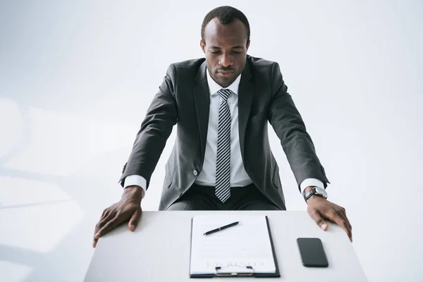 Empresário afro-americano no local de trabalho com documento — Fotografia de Stock