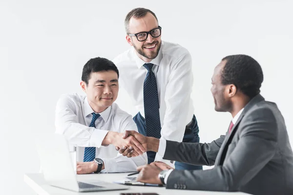 Empresarios multiétnicos dándose la mano - foto de stock