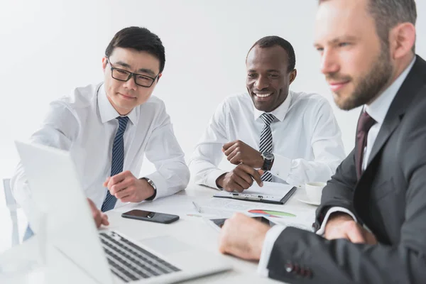 Multicultural businessmen using laptop — Stock Photo