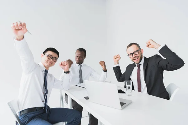 Empresarios multiculturales emocionados en el lugar de trabajo - foto de stock