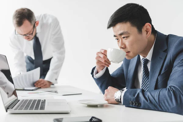 Asian businessman drinking coffee — Stock Photo