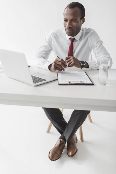 Uomo d'affari afroamericano sul posto di lavoro con documento — Foto stock