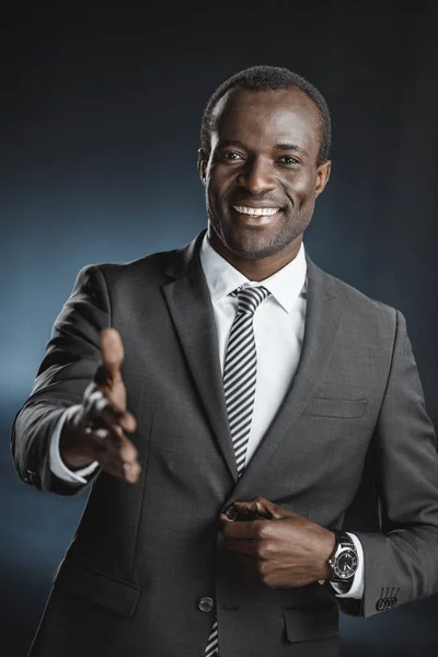 African american businessman with outstretched hand — Stock Photo