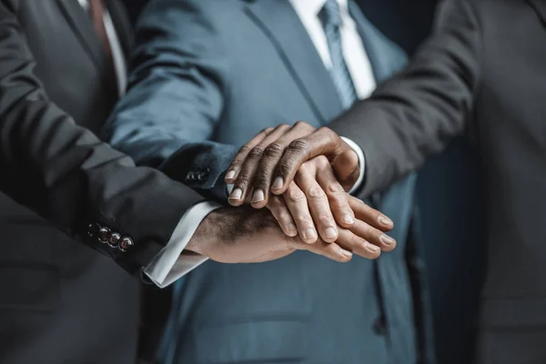 Hombres de negocios multiétnicos tomados de la mano - foto de stock