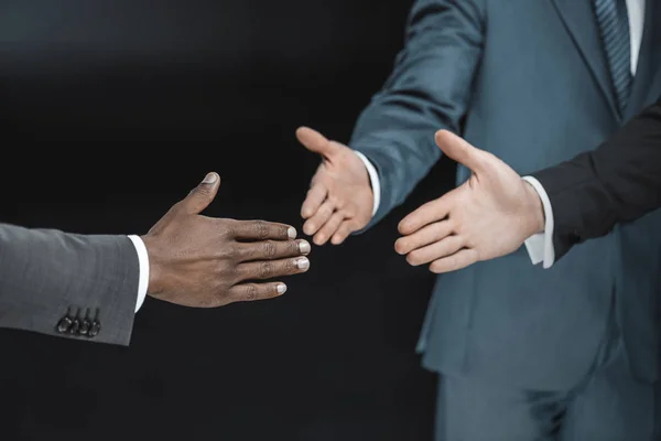 Multiethnic businessmen outstretching hands — Stock Photo
