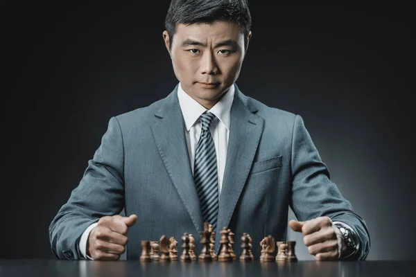 Asiatique homme d'affaires et pièces d'échecs — Photo de stock