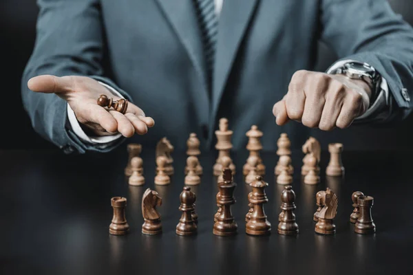 Figuras de hombre de negocios y ajedrez en la mesa - foto de stock