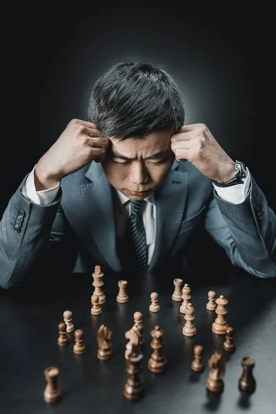 Asian businessman and chess pieces — Stock Photo