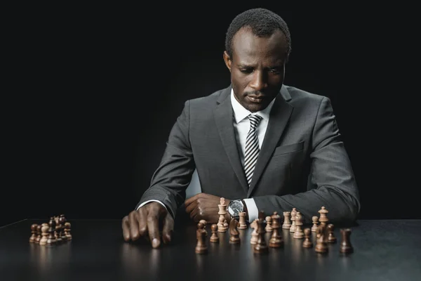 Hombres de negocios afroamericanos y figuras de ajedrez - foto de stock