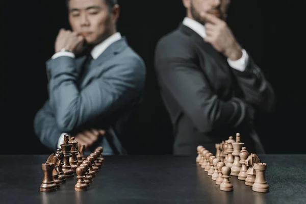 Мультиэтнические бизнесмены смотрят на шахматы — стоковое фото