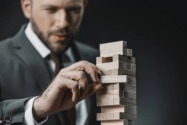 Uomo d'affari giocando blocchi di legno gioco — Foto stock