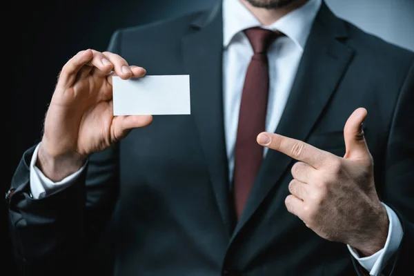 Businessman pointing at business card — Stock Photo