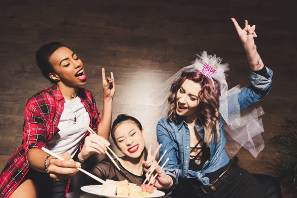 Mujeres multiculturales con sushi en despedida de soltera - foto de stock