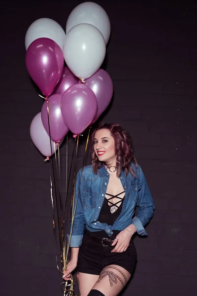 Jeune femme souriante avec des ballons — Photo de stock