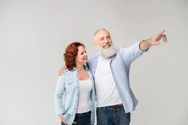 Couple hugging and pointing somewhere — Stock Photo