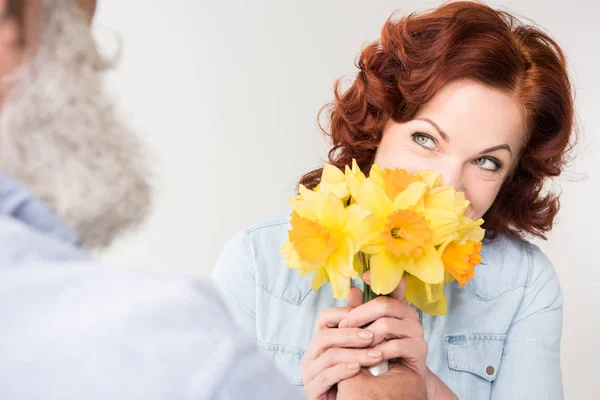 Mulher madura com narcisos — Fotografia de Stock