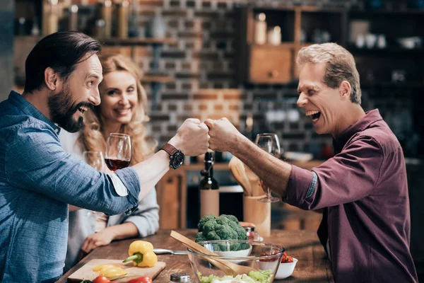 Amis boire du vin tout en cuisinant dîner — Photo de stock