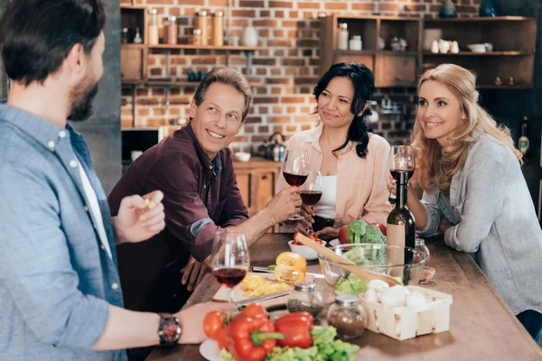 Amigos bebiendo vino durante la cena - foto de stock