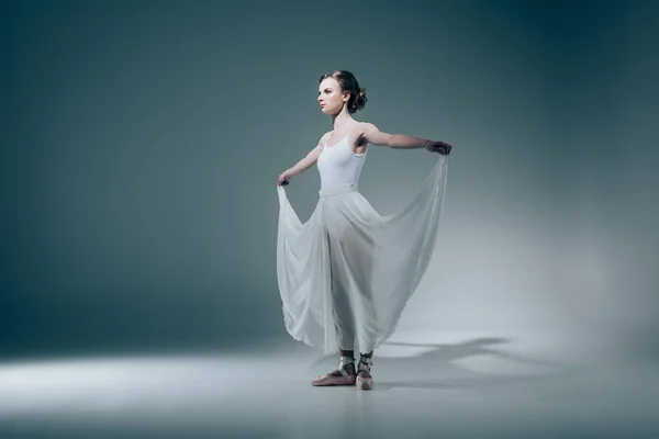 Elegant ballerina standing in white dress — Stock Photo