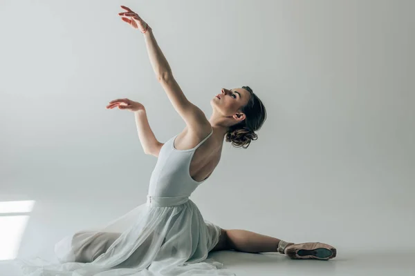 Bailarina elegante sentado em vestido branco e sapatos de balé — Fotografia de Stock