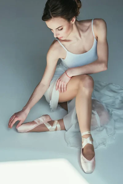 Belle ballerine assise en robe blanche et chaussures de ballet — Photo de stock